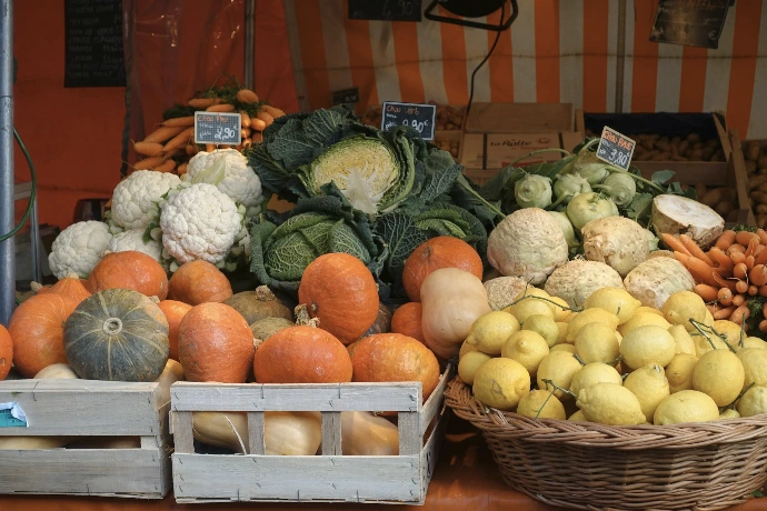 red apple fruit beside green vegetable on brown wooden crate