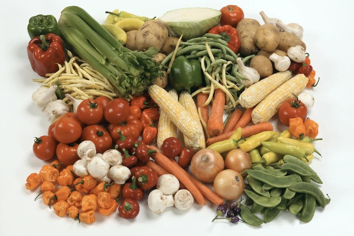 a pile of different types of vegetables on a white surface